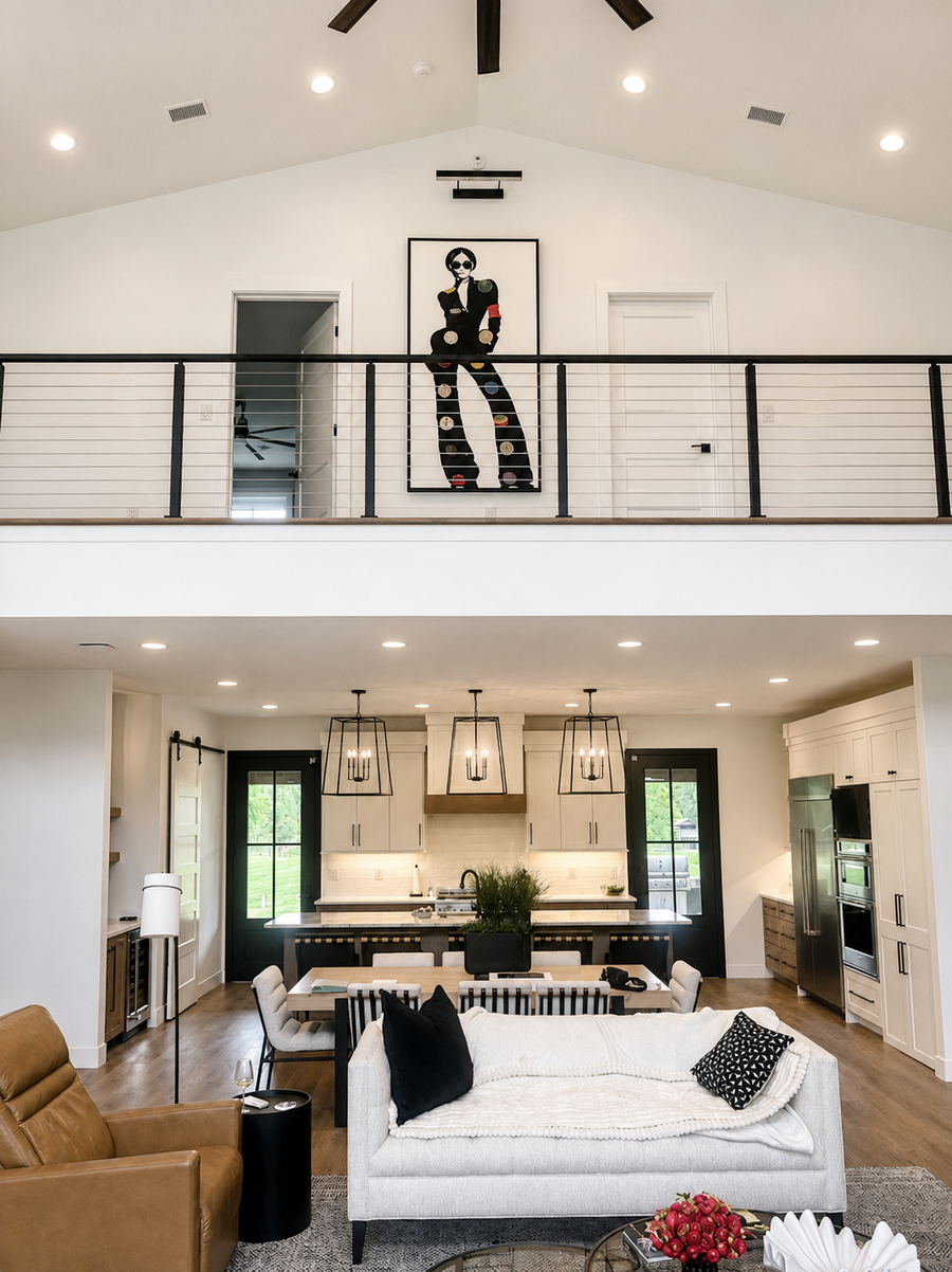 vinyl record art piece on second floor. Modern living room with white sofa, brown armchair, and kitchen in the background.